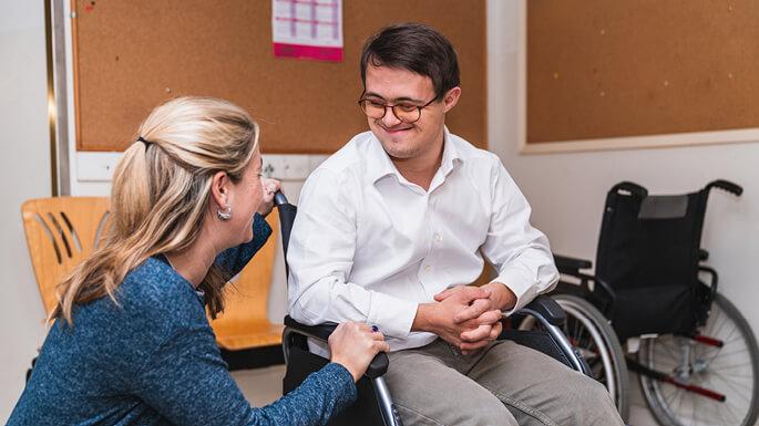 A caregiver sharing a warm moment with a smiling young man